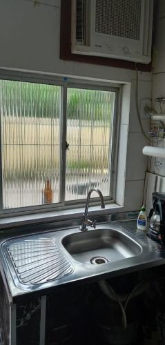 a sink in a kitchen with a window at kitnet próximo a praia in Rio de Janeiro