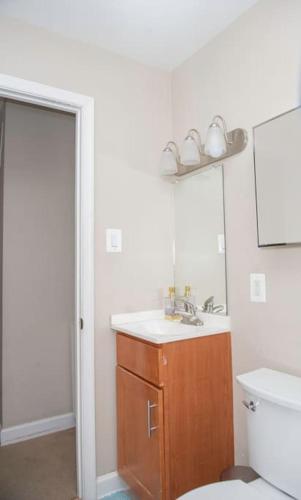 a bathroom with a sink and a toilet and a mirror at Entire Home in North Potomac in Potomac