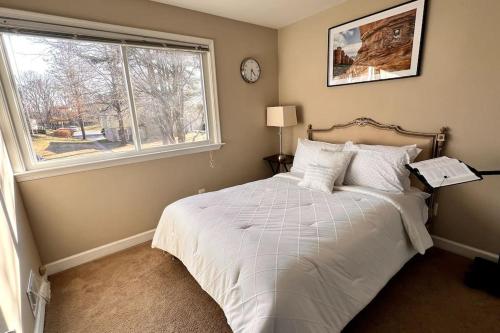 a bedroom with a white bed with a window at Entire Home in North Potomac in Potomac