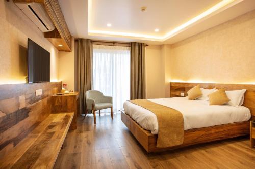 Habitación de hotel con cama y silla en HOTEL BHRIKUTI TARA, en Katmandú