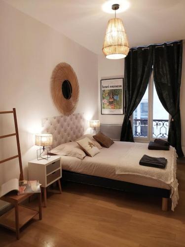 une chambre avec un grand lit et une fenêtre dans l'établissement L'ombre du Vieux-Port appartement spacieux, à Marseille