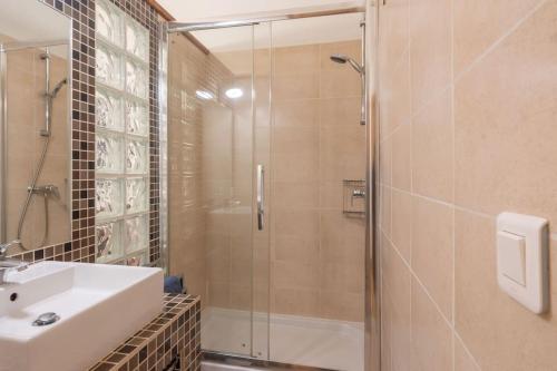 une salle de bain avec une douche en verre et un lavabo dans l'établissement L'ombre du Vieux-Port appartement spacieux, à Marseille