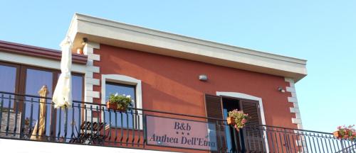 a building with a balcony with a sign on it at Anthea Dell' Etna in Santa Venerina