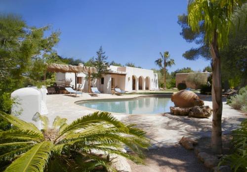 a swimming pool in front of a house at La Finca Agroturismo Can Bet in Santa Eularia des Riu