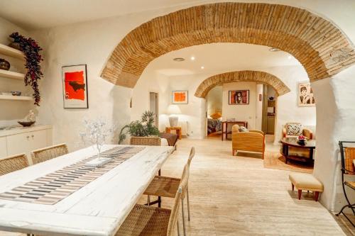 une salle à manger avec une grande table et un salon dans l'établissement Charming House by Hello Homes Sitges, à Sitges