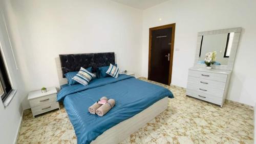 1 dormitorio con cama azul y espejo en Fresh Remodel Apt With New Ac, en Amán
