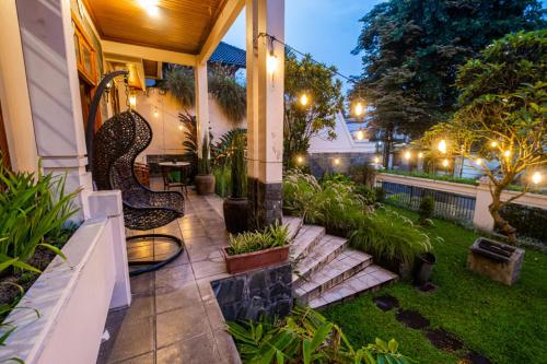 a patio with chairs and plants on a house at night at Andaru Sukahaji - Perfect for Family and Friends in Bandung