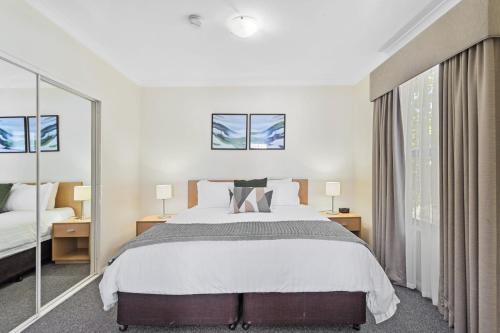 - une chambre avec un grand lit et 2 fenêtres dans l'établissement Northbridge Prime Location*2BR, à Perth