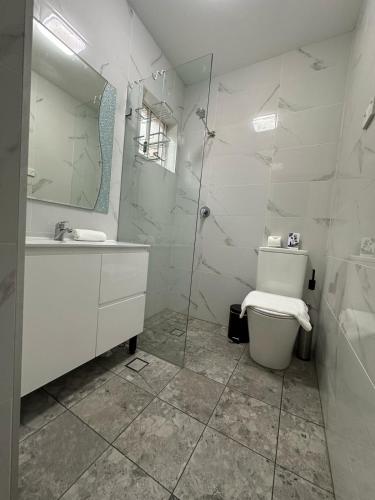 a white bathroom with a toilet and a sink at ROOM - BEXLEY NORTH in Sydney