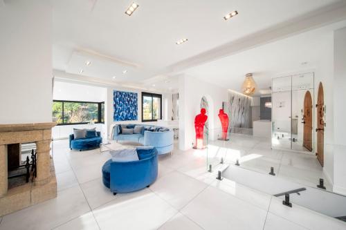 Elle comprend un salon doté d'un mobilier bleu et d'une cheminée. dans l'établissement REF 2134 - Cannes - Magnificent villa for rent, à Cannes