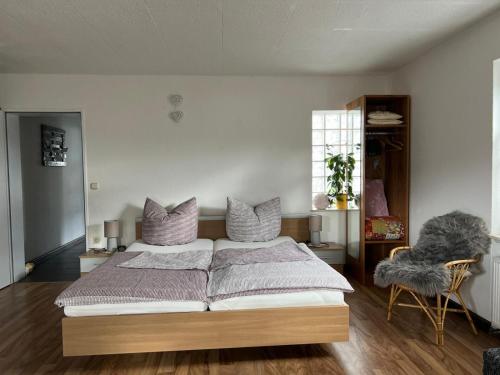 a bedroom with a large bed and a chair at Ferienwohnung Chaves in Bad Karlshafen