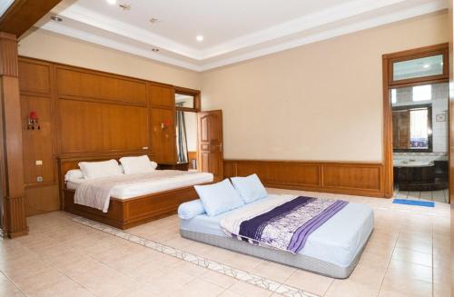a large bedroom with two beds and a window at Andaru Sukahaji - Perfect for Family and Friends in Bandung