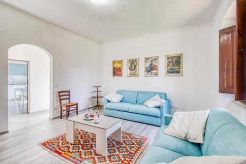 een woonkamer met een blauwe bank en een tafel bij La Casa Della Quercia Relax In Tuscany - Happy Rentals in Montaione