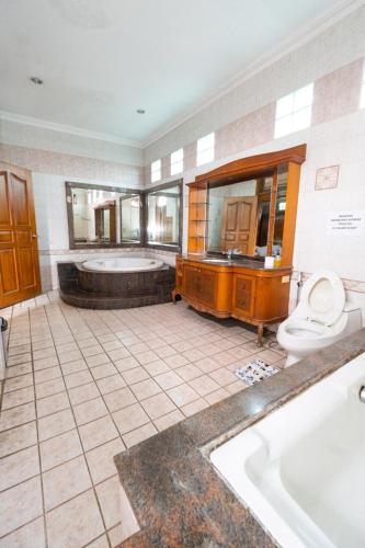 a bathroom with a tub and a toilet and a sink at Andaru Sukahaji - Perfect for Family and Friends in Bandung