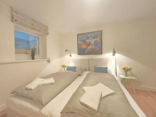 ein Schlafzimmer mit einem großen Bett mit zwei Kissen in der Unterkunft Ferienhaus Cäcilienhof West in Kampen