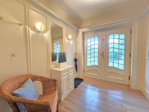 坎彭的住宿－Ferienhaus Cäcilienhof West，客厅配有柳条椅和镜子