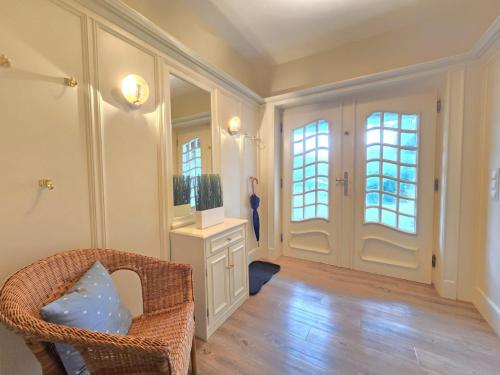 ein Wohnzimmer mit einem Korbstuhl und einem Spiegel in der Unterkunft Ferienhaus Cäcilienhof West in Kampen