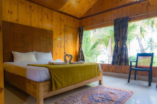 ein Schlafzimmer mit einem Bett, einem Stuhl und einem Fenster in der Unterkunft GRAND OCEANUS RESORT in Beadonābād