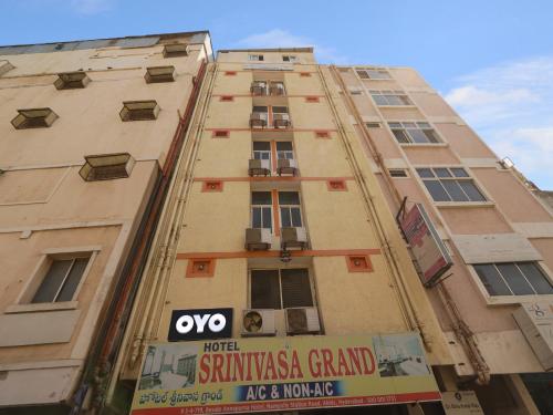海得拉巴的住宿－OYO Hotel Srinivasa Grand，一座高大的建筑,旁边有一个标志