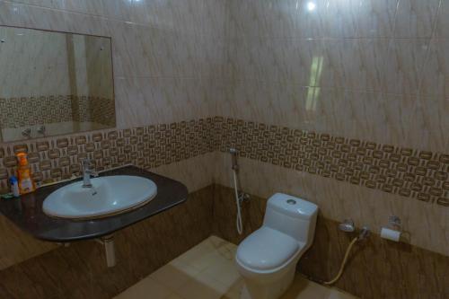 a bathroom with a sink and a toilet and a mirror at GRAND OCEANUS RESORT in Beadonābād