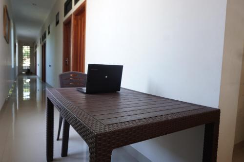 a laptop computer sitting on a wooden table at OYO 93731 Amas Syariah in Parepare