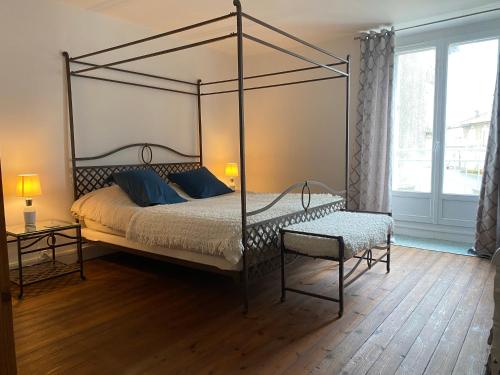 una camera da letto con un letto a baldacchino e una sedia di Charming 1-bed cottage Montemboeuf a Montembœuf
