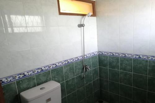 uma casa de banho com um WC e um chuveiro em OYO 93764 Homestay Citra em Kendari