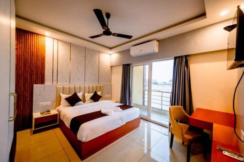 a bedroom with a bed and a large window at Goroomgo Shree Gajanana Puri Near Sea Beach - Lift Facilities - Best Selling in Puri