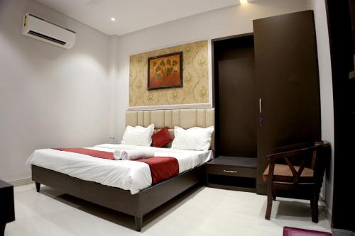een slaapkamer met een groot bed en een stoel bij Hotel Swastik 5 Minutes walking From Golden Temple in Amritsar