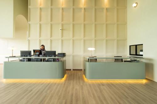 a woman sitting at a desk in an office at Amber Cove Premier Suites Melaka in Melaka