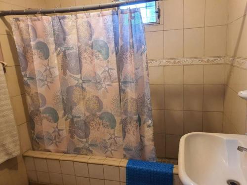 bagno con tenda per la doccia e lavandino di House for 5 with vehicle included in Roatan a Coxen Hole