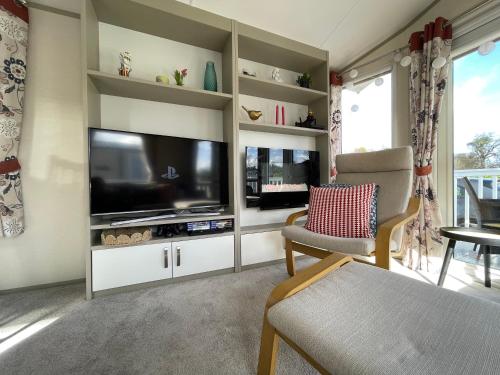 a living room with a flat screen tv and a couch at Seton Sands Caravan Near Edinburgh & North Berwick in Port Seton