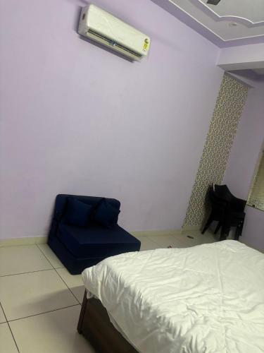 1 dormitorio con 1 cama y 1 silla azul en kanha hotel and resturant, en Dausa
