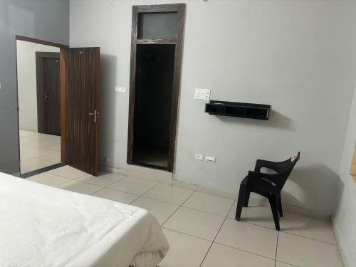 Un dormitorio con una silla negra y una cama en kanha hotel and resturant, en Dausa