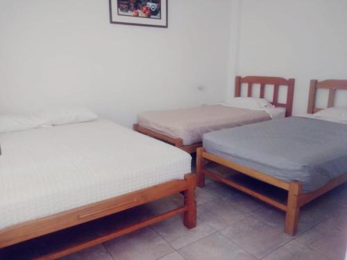 eine Gruppe von 3 Betten in einem Zimmer in der Unterkunft HOSPEDAJE PARACAS SUR in Paracas