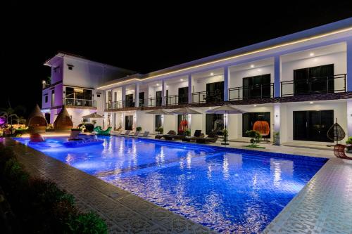 a swimming pool in front of a building at night at Sonrisa Resort De Playa by Hiverooms in San Remigio
