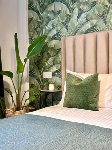 a bed with a green pillow next to a plant at Appartametno moderno centro di casa in Casablanca