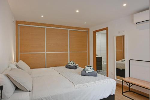 ein Schlafzimmer mit einem großen weißen Bett mit zwei Kameras darauf in der Unterkunft City Center Penthouse by NRAS in Alicante