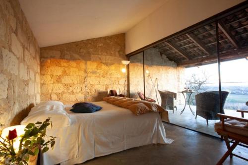 um quarto com uma cama grande numa parede de pedra em Cascina Rosa B&B em Grazzano Badoglio