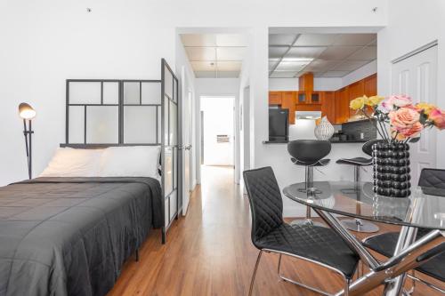 1 dormitorio con 1 cama y 1 mesa con sillas en 1-BDRM Apartment with Balcony - Heart of Downtown and Wynwood en Miami