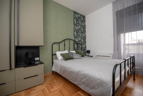 una camera da letto con un letto e una televisione di WOW Apartman u centru Trebinja a Trebinje