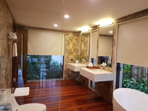 łazienka z 2 umywalkami i 2 lustrami w obiekcie Flamingo Đại Lải Resort Villa Được Nấu Nướng, Ở Đông, BBQ, Karaoke w mieście Ngọc Quang