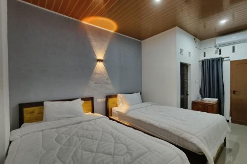 Un pat sau paturi într-o cameră la OYO 93709 Rose Inn 2