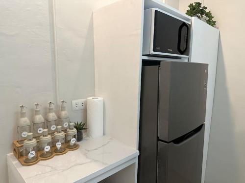 een kleine keuken met een koelkast en een magnetron bij Japandi Home C - Fully Aircon, WIFI, Hot shower, 24hGuard, Center, near Malls in General Santos