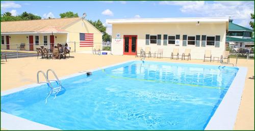 a large blue swimming pool in front of a building at Lodge at Kennebunk in Kennebunk