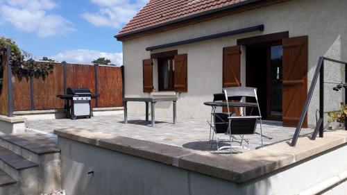 un patio con sillas, una mesa y una parrilla en sarnago, en Samois-sur-Seine