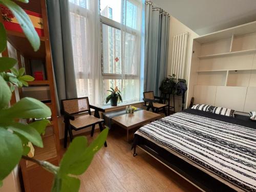 a bedroom with a bed and chairs and a table at Chaoyang Joy City Hardcover Apartment in Beijing
