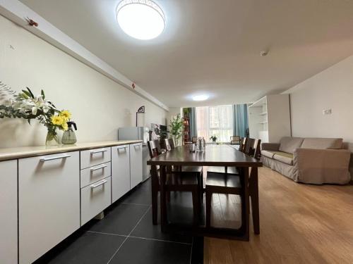 a kitchen and living room with a table and a couch at Chaoyang Joy City Hardcover Apartment in Beijing