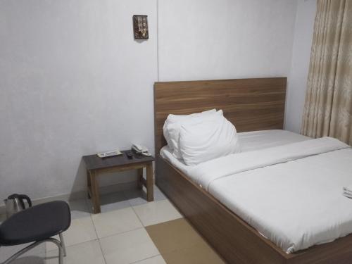 sypialnia z łóżkiem, stołem i krzesłem w obiekcie Mid Way Best Hotel w mieście Lagos