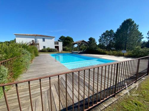 une piscine avec une terrasse en bois à côté d'une maison dans l'établissement Appartement 4 Pers - Cala Rossa - Piscine, à Lecci